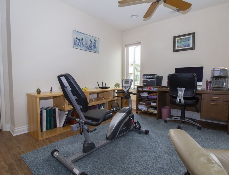 Open loft with newly installed windows, desk area and work-out equipment.
