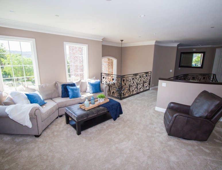 Large family room with ample lighting, wall-mounted television and plenty of seating