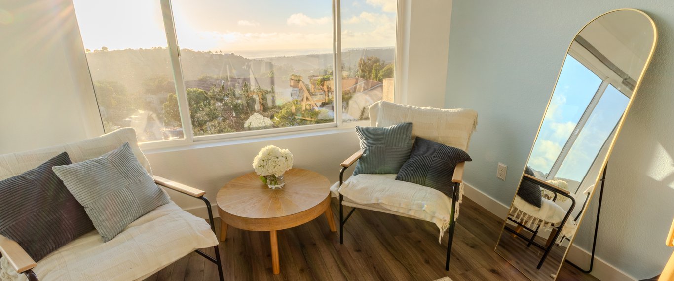 Upper landing after renovation with white half wall, light flooring, recessed lighting, and overlook into the living area below.