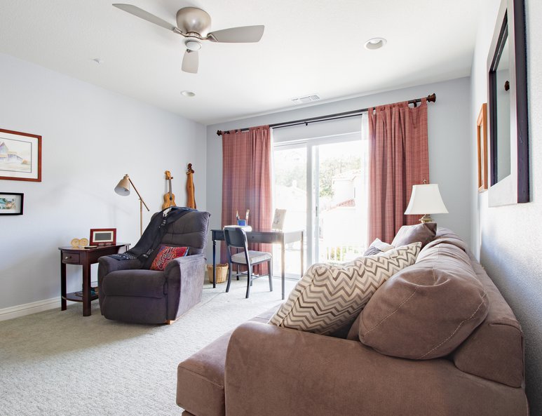 Sitting area in family room with sliding glass doors leading to existing balcony