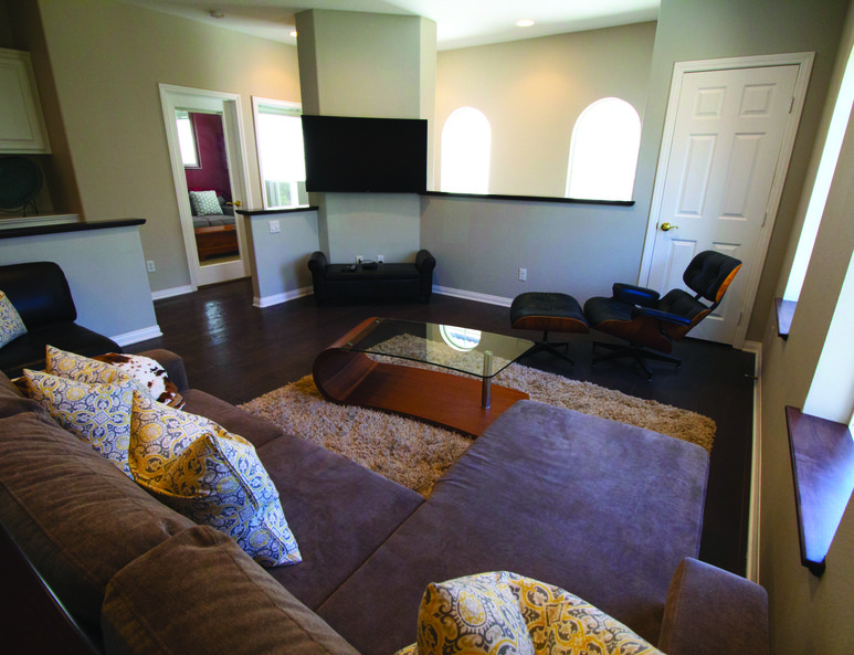 Modern family room with newly built closet, wall-mounted tv and ceiling fan