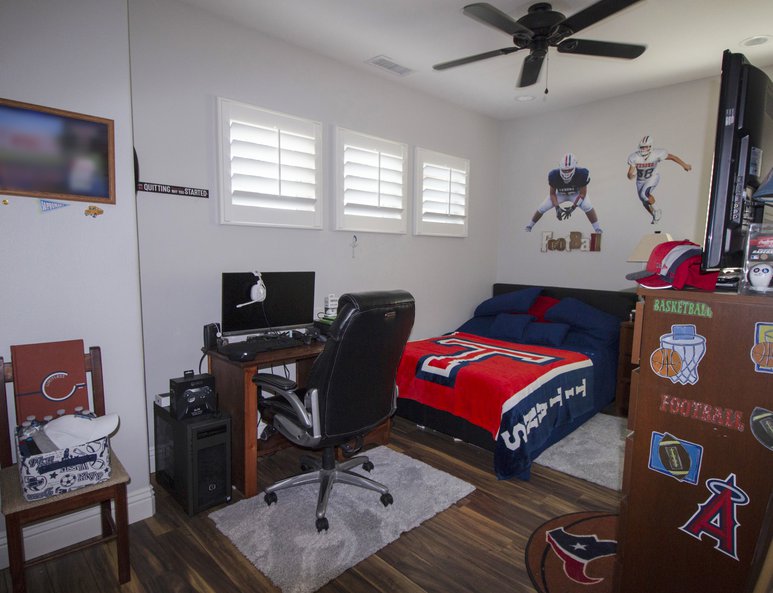 Teen bedroom with sports memorabilia and three square windows.