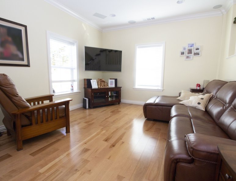 High ceiling space turned into a living room with recessed lighting and ample lighting