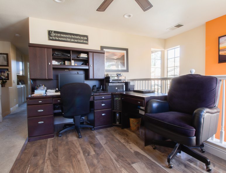 Open loft is used as a home office with white wood railing