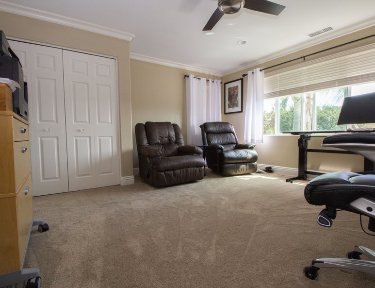 Bonus bedroom being utilized as a home office with closet space and bathroom