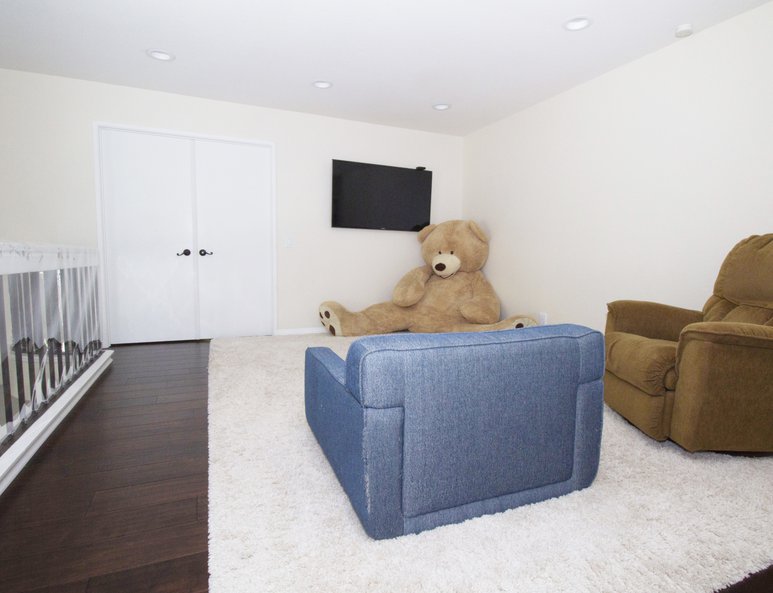 Family room with wrought iron railing and white wood cap