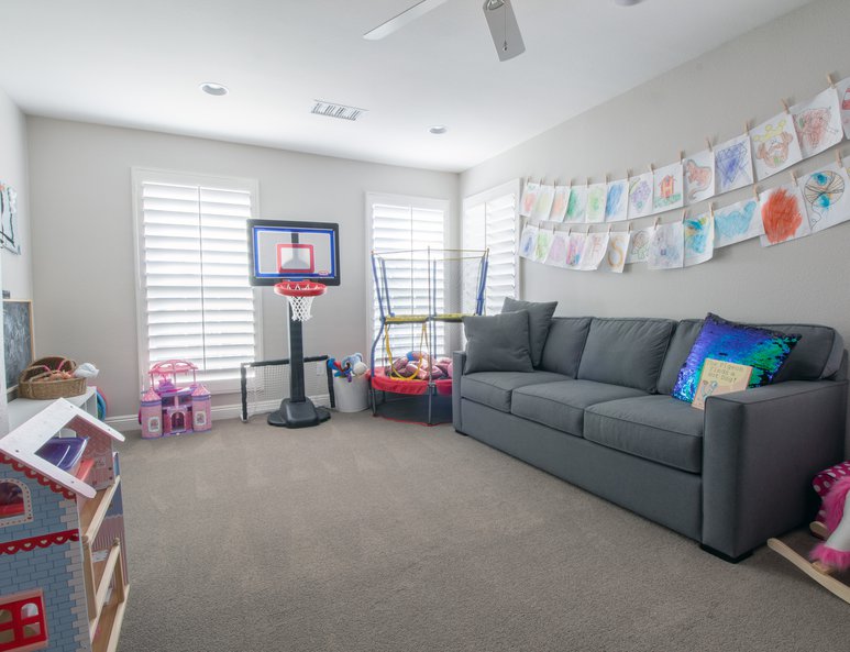 Open loft playroom with multiple windows and toys.