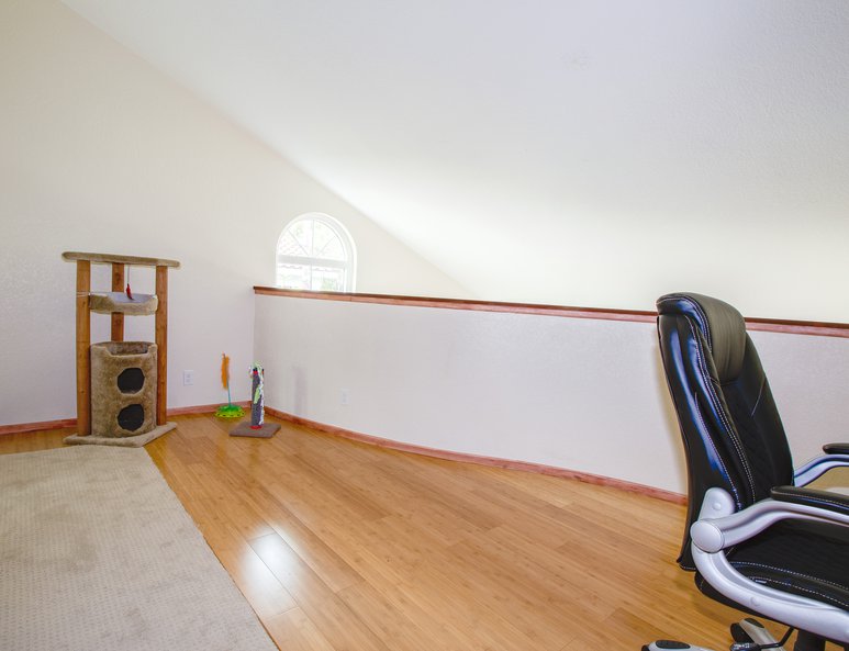 Curved ponywall in open loft with cherry wood baseboards and cap