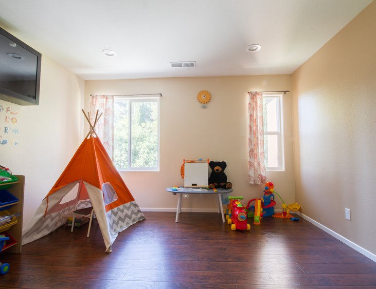 Bonus room being utilized as a playroom with extra storage.