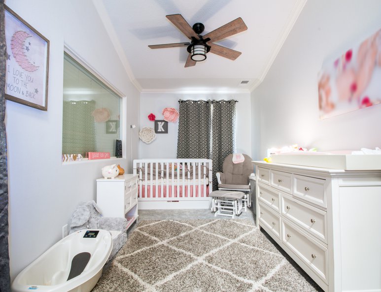 Open loft being utilized as a nursery with curtain doors.